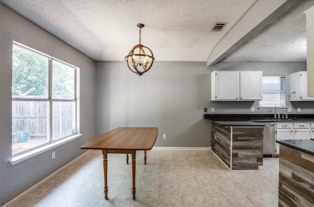 interior space with sink, a textured ceiling, and an inviting chandelier