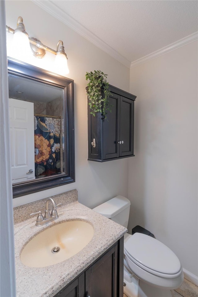 bathroom with ornamental molding, vanity, and toilet