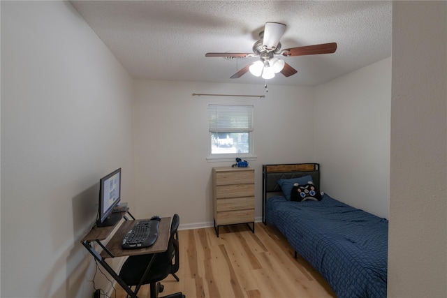 bedroom featuring a textured ceiling, light wood-type flooring, and ceiling fan