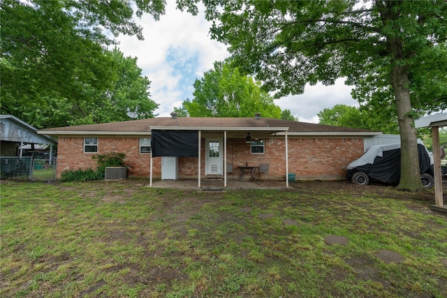 back of house with a yard and central AC