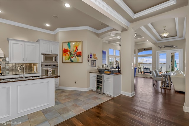 kitchen featuring light wood-type flooring, wine cooler, backsplash, and white cabinetry