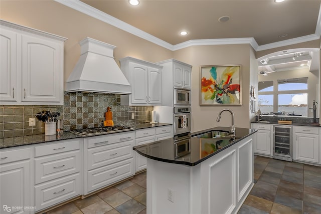 kitchen with white cabinetry, sink, beverage cooler, stainless steel appliances, and custom range hood