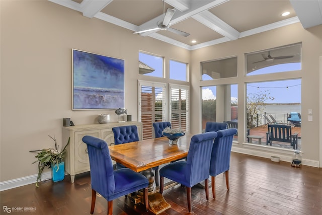 dining space featuring dark hardwood / wood-style flooring, ornamental molding, ceiling fan, beam ceiling, and a water view