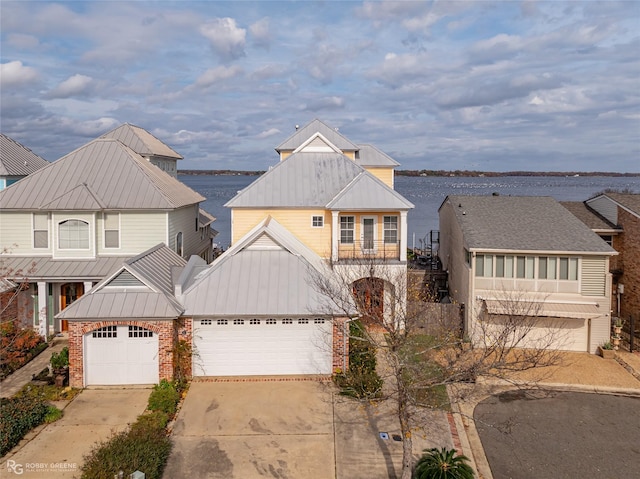 view of front facade featuring a balcony, a water view, and a garage