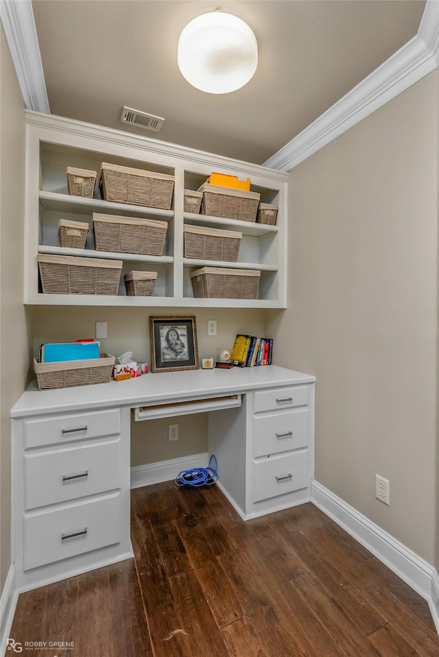 unfurnished office with dark hardwood / wood-style flooring, built in desk, and ornamental molding