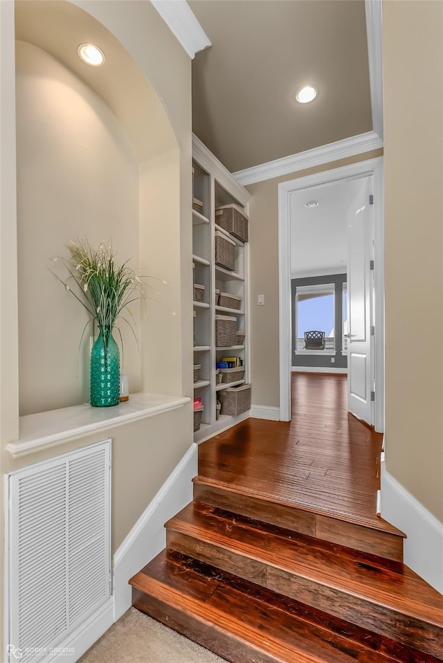 staircase with crown molding and hardwood / wood-style floors