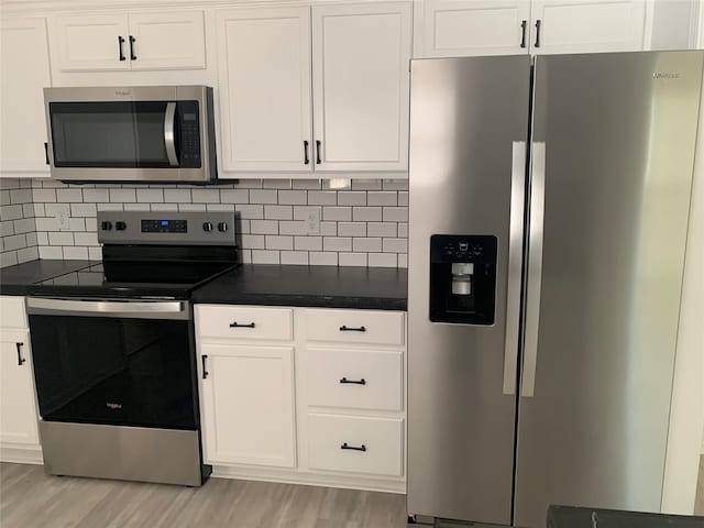 kitchen with white cabinetry, stainless steel appliances, and light wood-type flooring