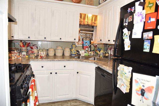 kitchen featuring white cabinetry, sink, black appliances, and light hardwood / wood-style flooring