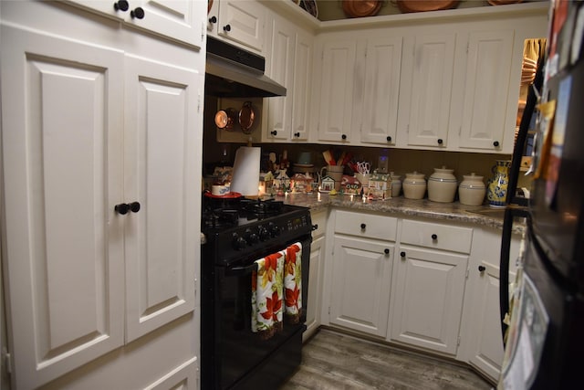 kitchen with black gas range, white cabinetry, dark hardwood / wood-style flooring, and fridge