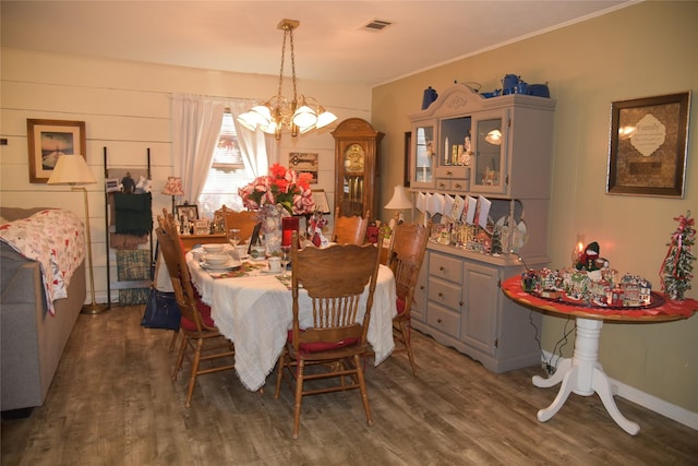 dining area with dark hardwood / wood-style floors and an inviting chandelier