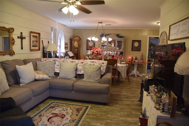 living room with hardwood / wood-style floors, ceiling fan with notable chandelier, and crown molding