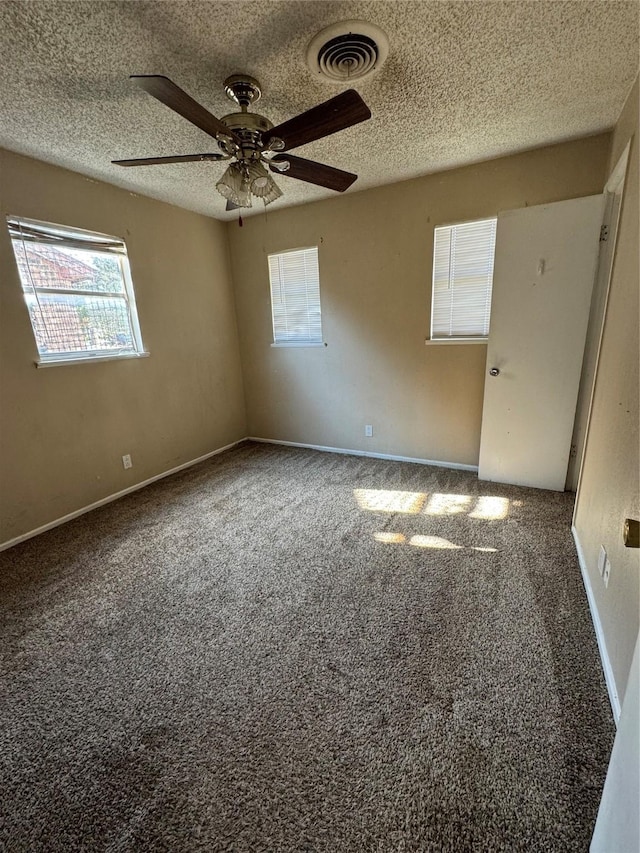 spare room with carpet flooring, ceiling fan, and a textured ceiling