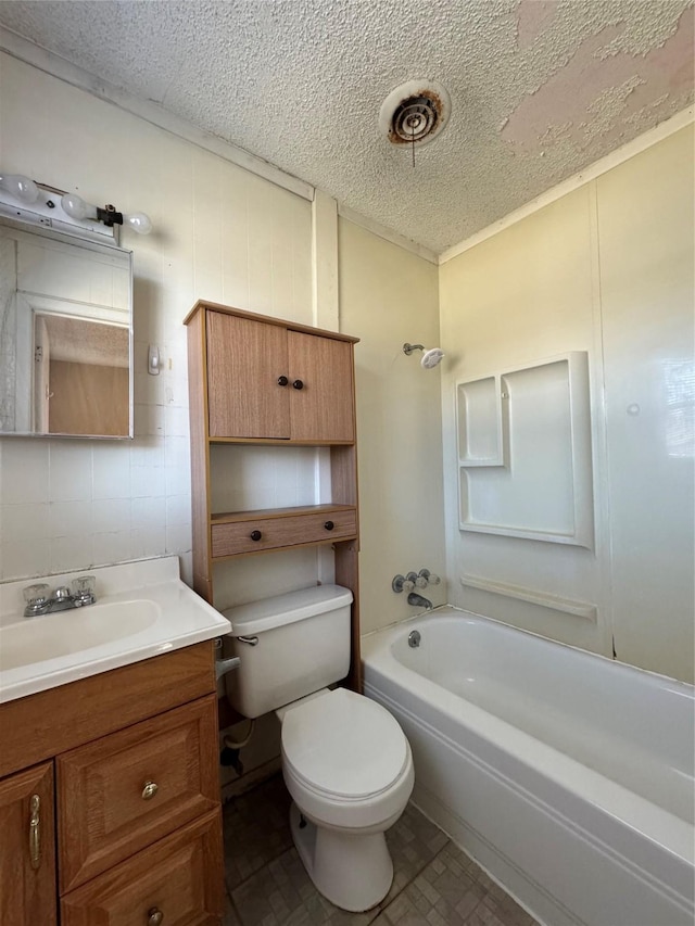 full bathroom featuring toilet, vanity, a textured ceiling, and washtub / shower combination