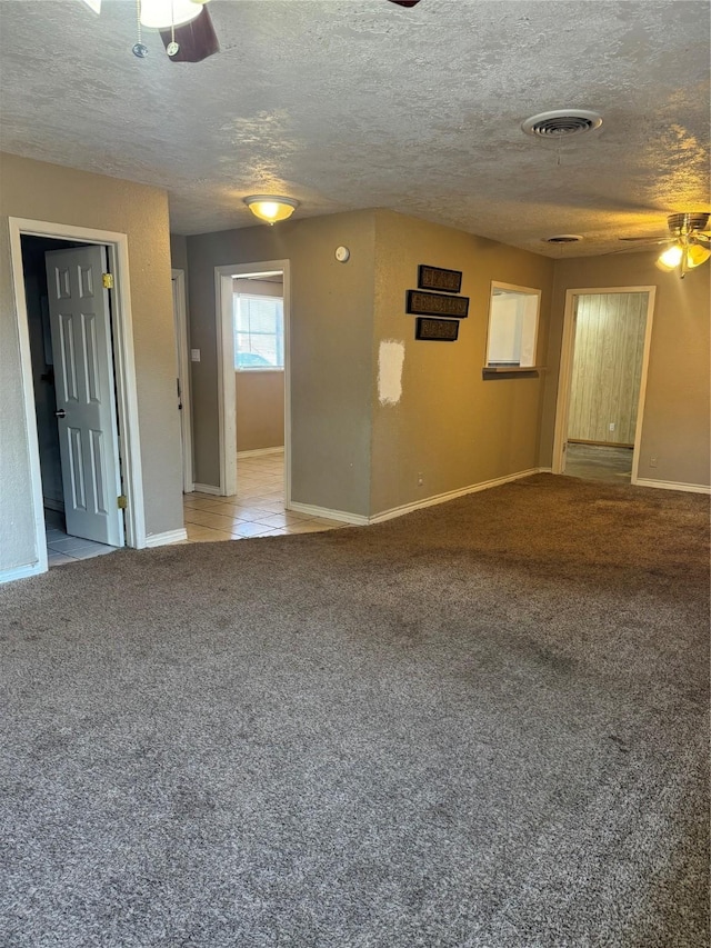 carpeted empty room featuring ceiling fan and a textured ceiling