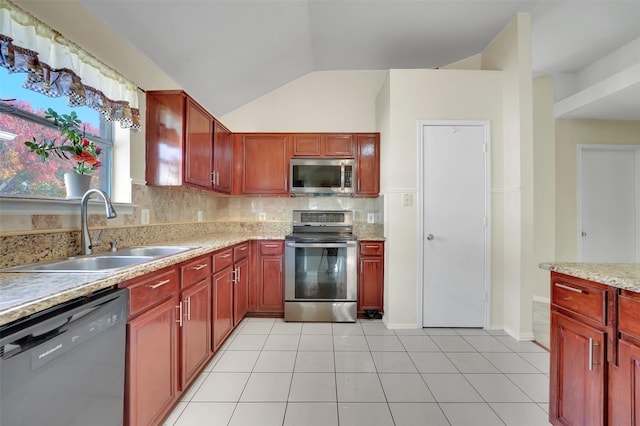 kitchen with backsplash, sink, vaulted ceiling, light tile patterned floors, and appliances with stainless steel finishes