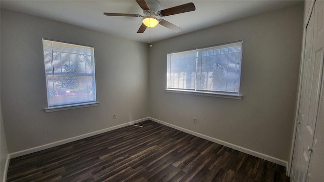 empty room with ceiling fan and dark hardwood / wood-style flooring