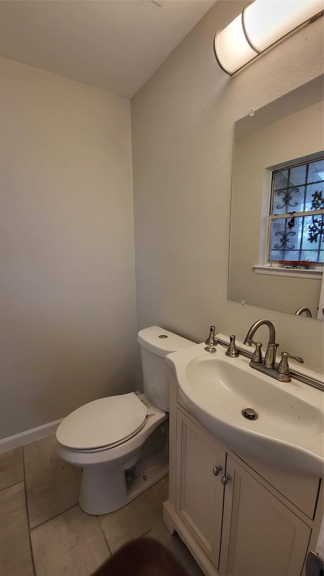 bathroom with tile patterned flooring, vanity, and toilet