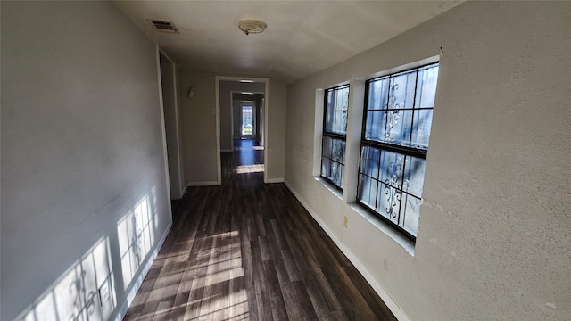 corridor with dark hardwood / wood-style flooring