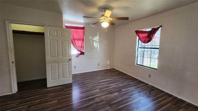 unfurnished bedroom with ceiling fan, a closet, and dark wood-type flooring