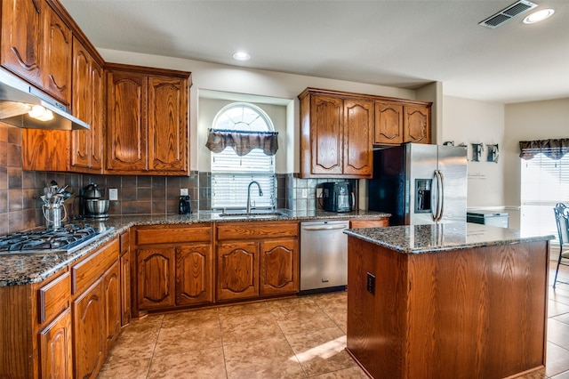 kitchen with sink, a kitchen island, tasteful backsplash, and stainless steel appliances