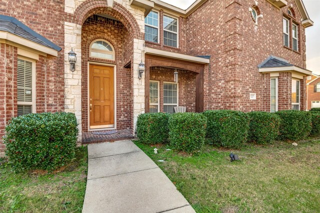 view of exterior entry with a lawn