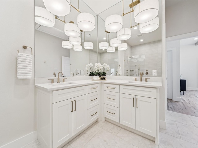 bathroom featuring tiled shower, tile patterned flooring, and vanity