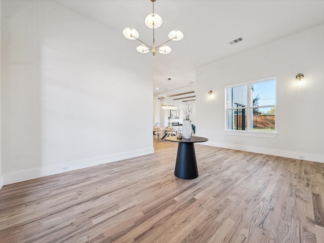 empty room with an inviting chandelier and light wood-type flooring