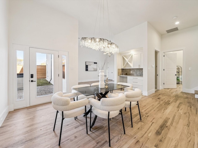 dining room with an inviting chandelier and light hardwood / wood-style flooring