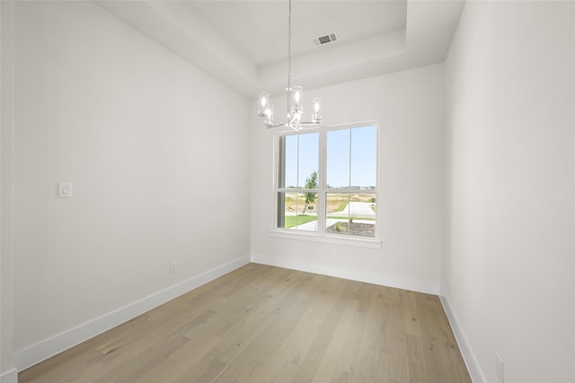 313 Slimp Blf, Azle, TX 76020 - unfurnished room featuring a chandelier, a raised ceiling, and light wood-style floors