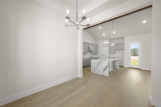 313 Slimp Blf, Azle, TX 76020 - kitchen with a chandelier, gray cabinets, light wood-type flooring, vaulted ceiling, and a kitchen island with sink
