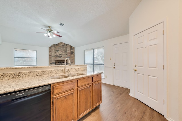 kitchen featuring light wood-type flooring, ceiling fan, sink, dishwasher, and lofted ceiling