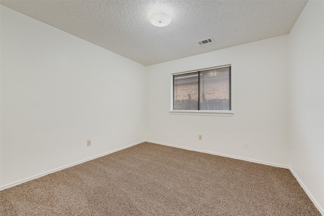 carpeted empty room with a textured ceiling