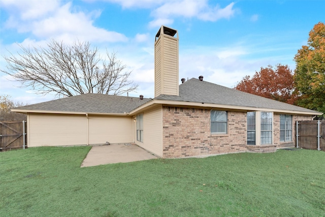 back of house with a yard and a patio