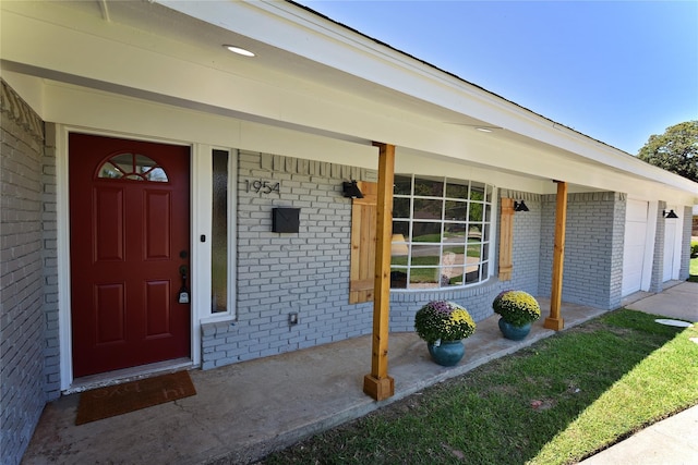 doorway to property featuring a porch and a garage