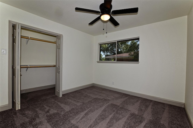 unfurnished bedroom featuring ceiling fan, a closet, and dark colored carpet