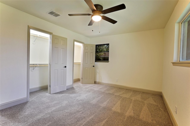 unfurnished bedroom featuring ceiling fan, light carpet, and a closet