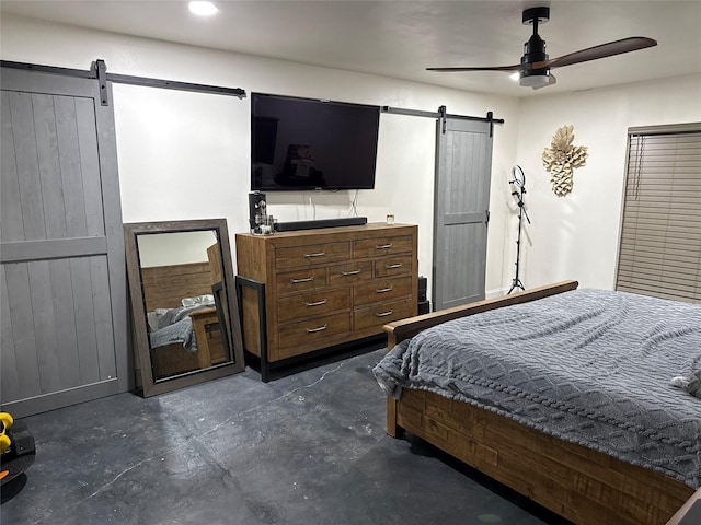 bedroom with ceiling fan and a barn door