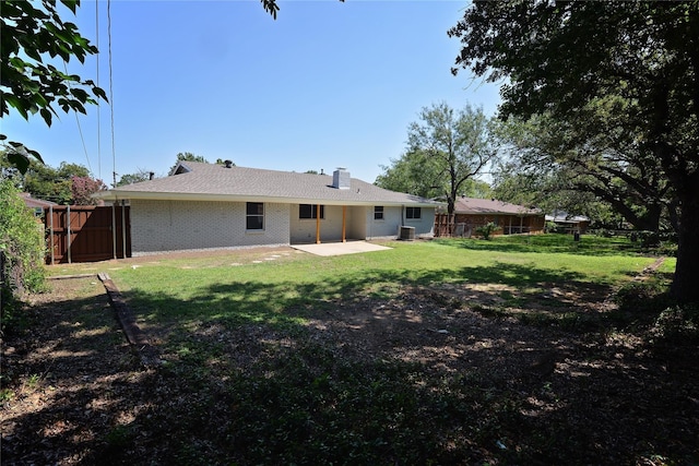 rear view of house with cooling unit, a yard, and a patio area