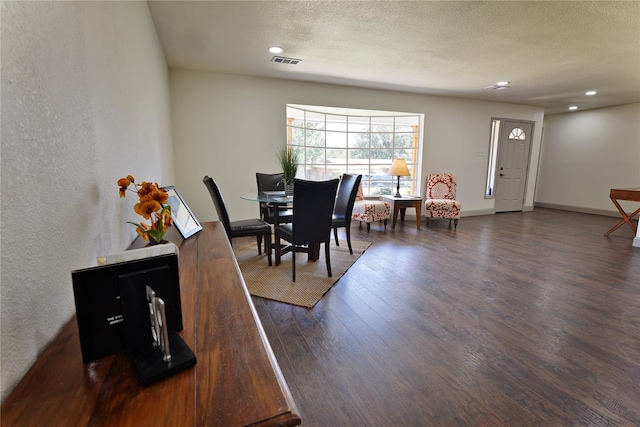 dining room with dark hardwood / wood-style flooring and a textured ceiling