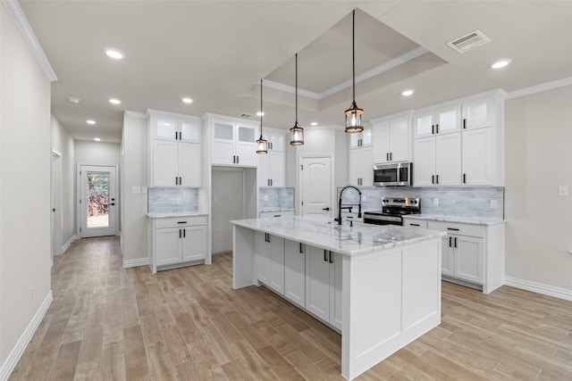 kitchen featuring white cabinetry, a center island with sink, and stainless steel appliances