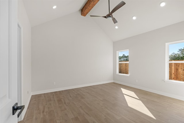 spare room featuring ceiling fan, a healthy amount of sunlight, light hardwood / wood-style floors, and beam ceiling