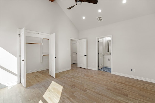 unfurnished bedroom with ceiling fan, light wood-type flooring, high vaulted ceiling, and a closet