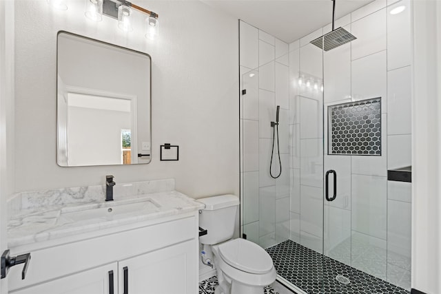 bathroom with vanity, a shower with shower door, and toilet