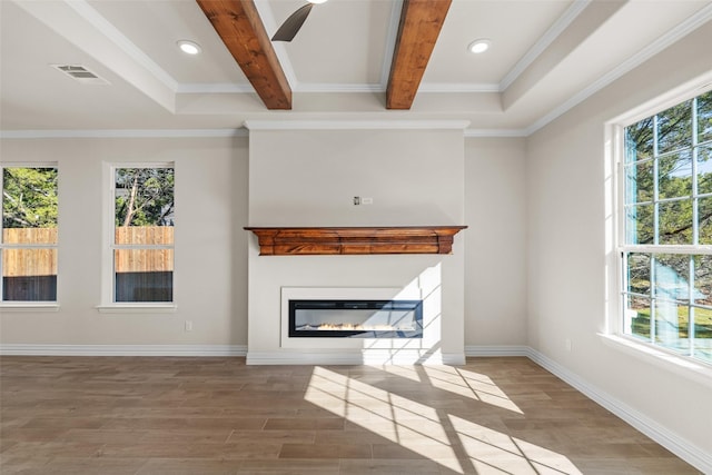 unfurnished living room with plenty of natural light, beamed ceiling, and hardwood / wood-style floors