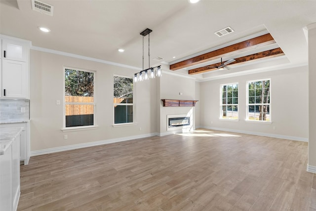 unfurnished living room with beam ceiling, ceiling fan, ornamental molding, and light wood-type flooring