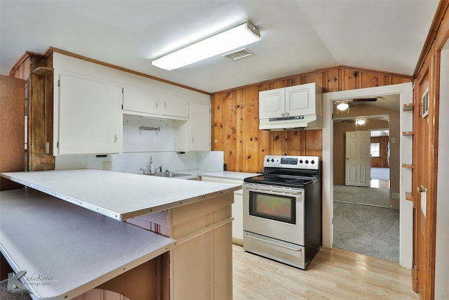 kitchen featuring white cabinets, lofted ceiling, electric range, and kitchen peninsula