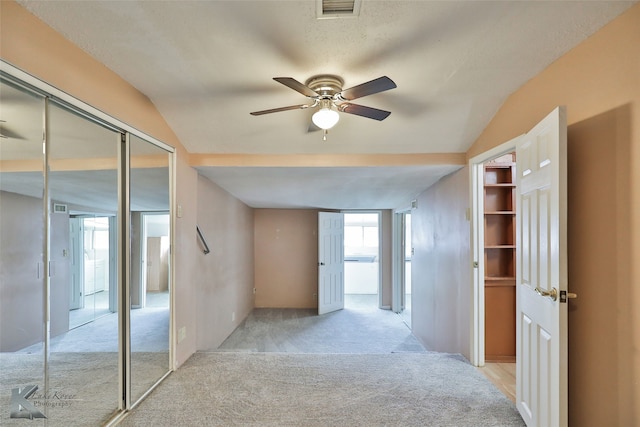 hallway with lofted ceiling and light carpet