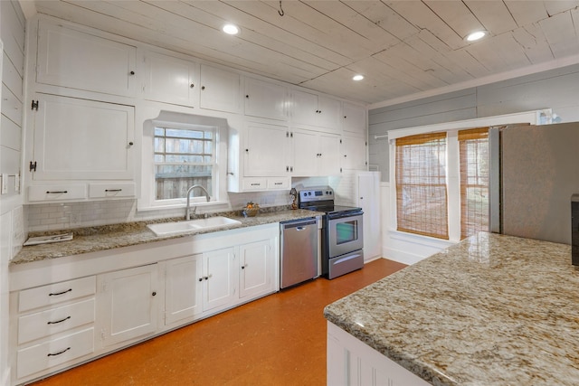 kitchen with white cabinets, light stone counters, sink, and stainless steel appliances