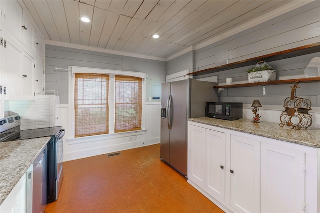 kitchen featuring appliances with stainless steel finishes, tasteful backsplash, light stone counters, white cabinetry, and wood walls