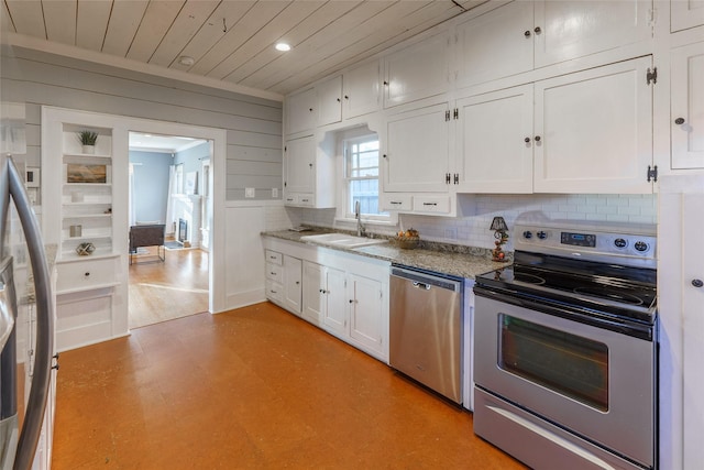 kitchen with stone counters, sink, backsplash, white cabinets, and appliances with stainless steel finishes